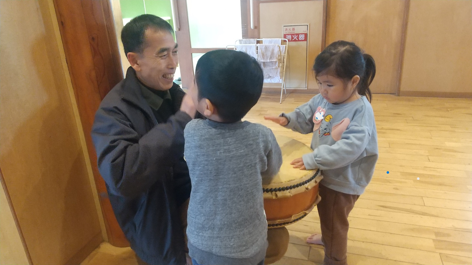 スタッフと一緒に太鼓をたたく子どもたち