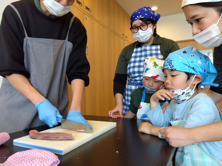 魚が捌かれている様子を見る子どもたち