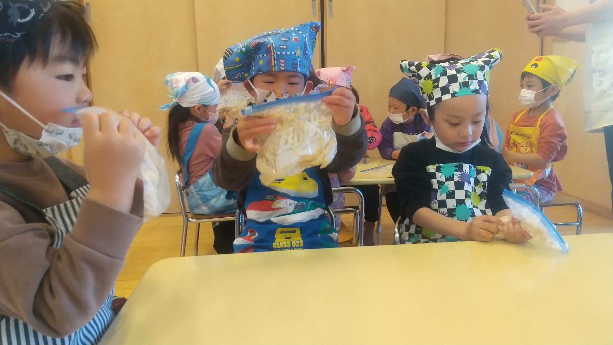 ジッパー付きポリ袋に大豆を入れて潰す子どもたち