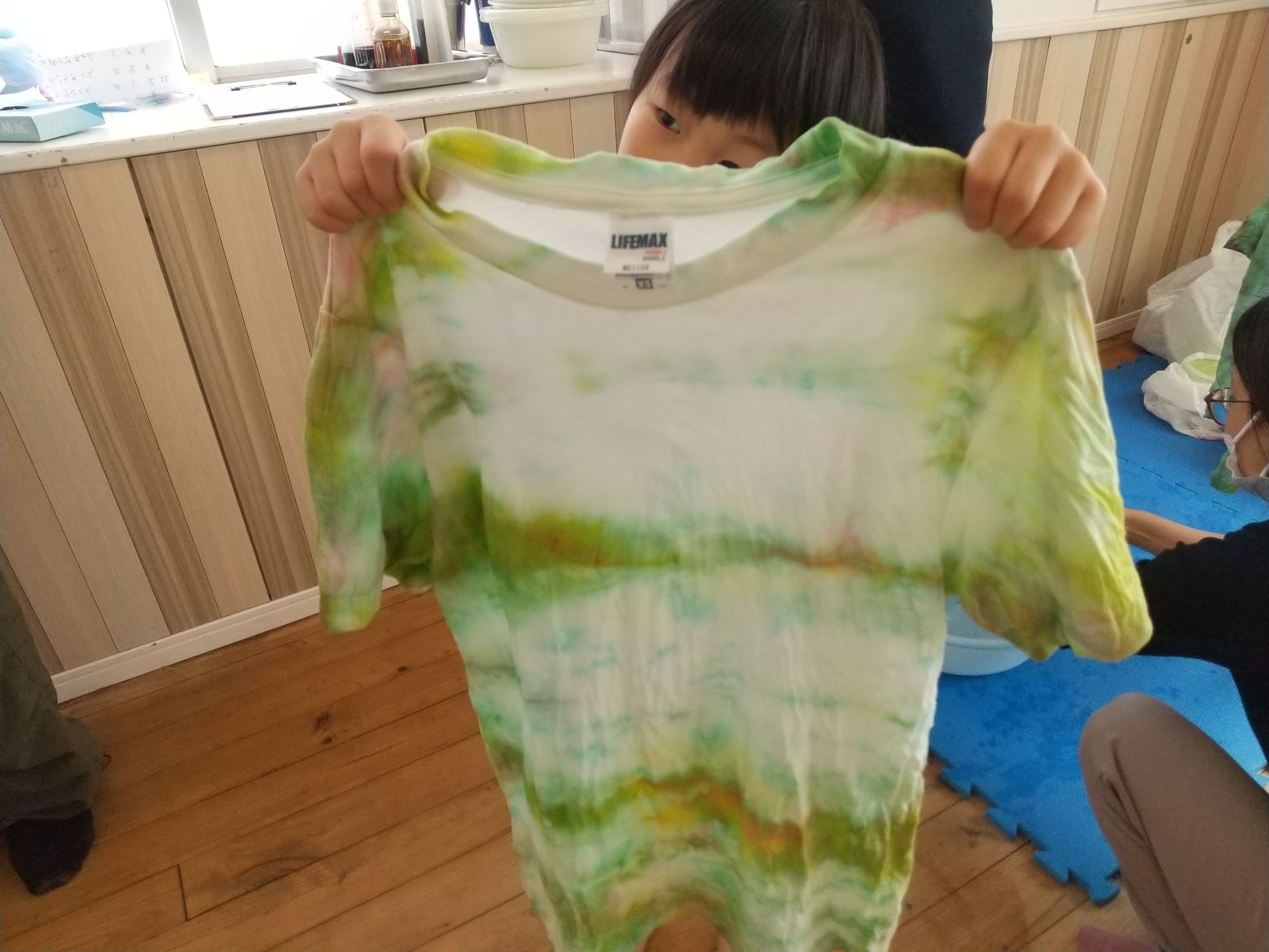 染めたTシャツを広げて見せる子ども