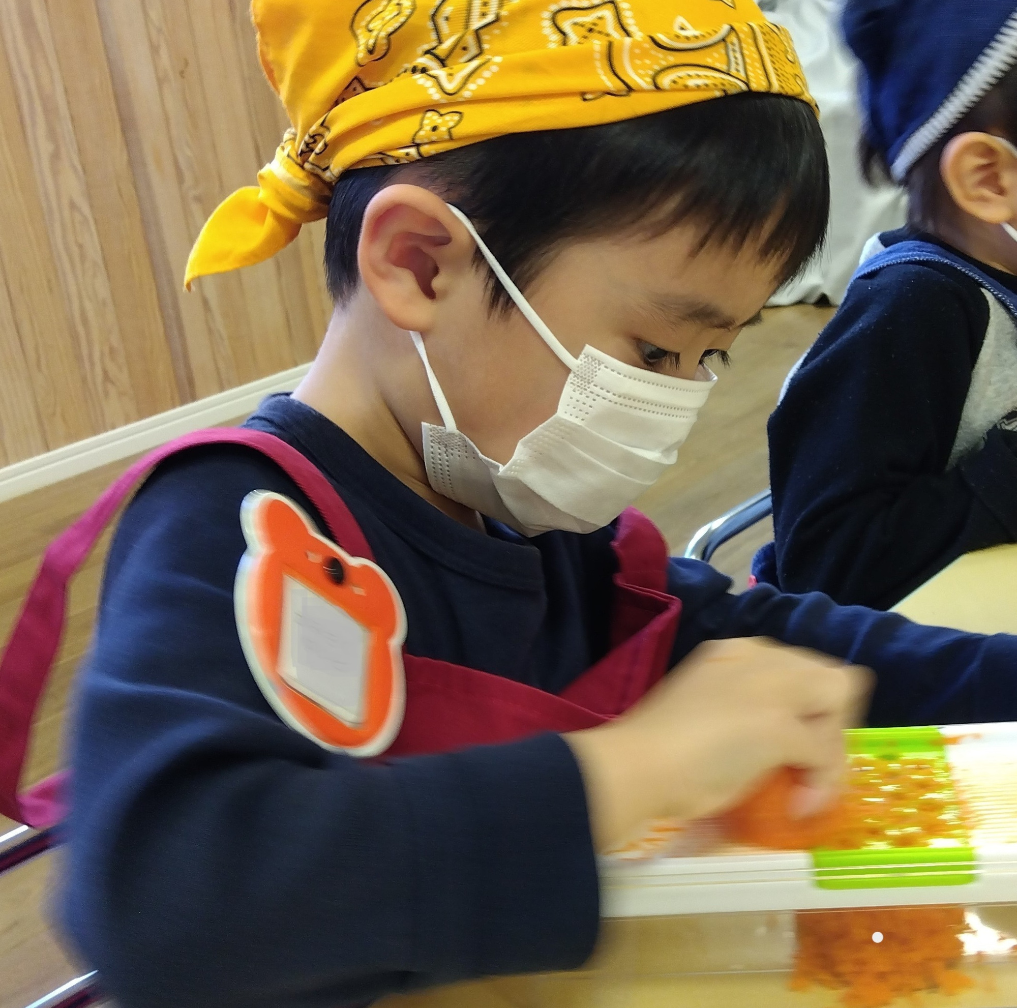 ニンジンをすりおろす子ども