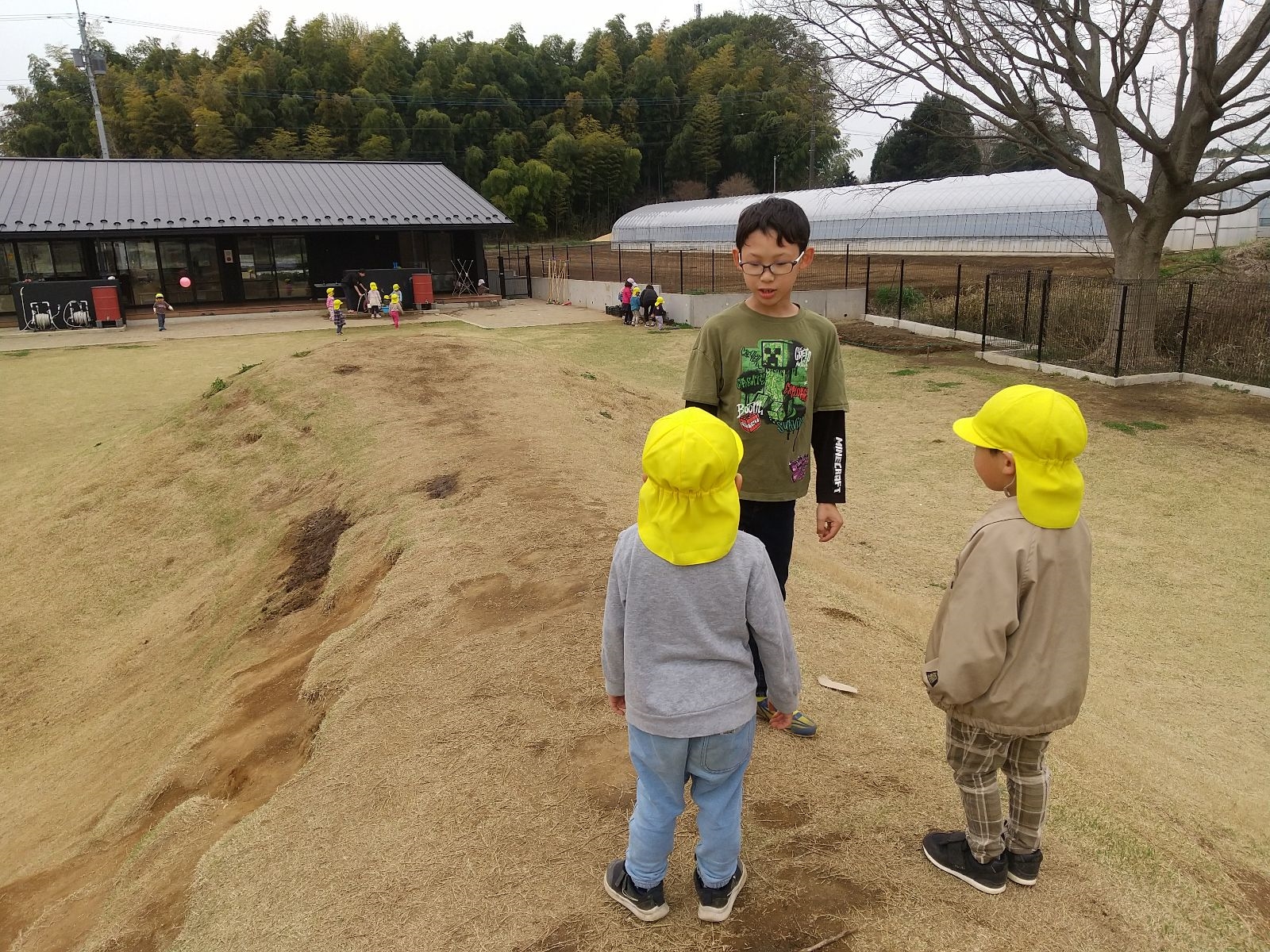 幼児と園庭で遊ぶ小学生