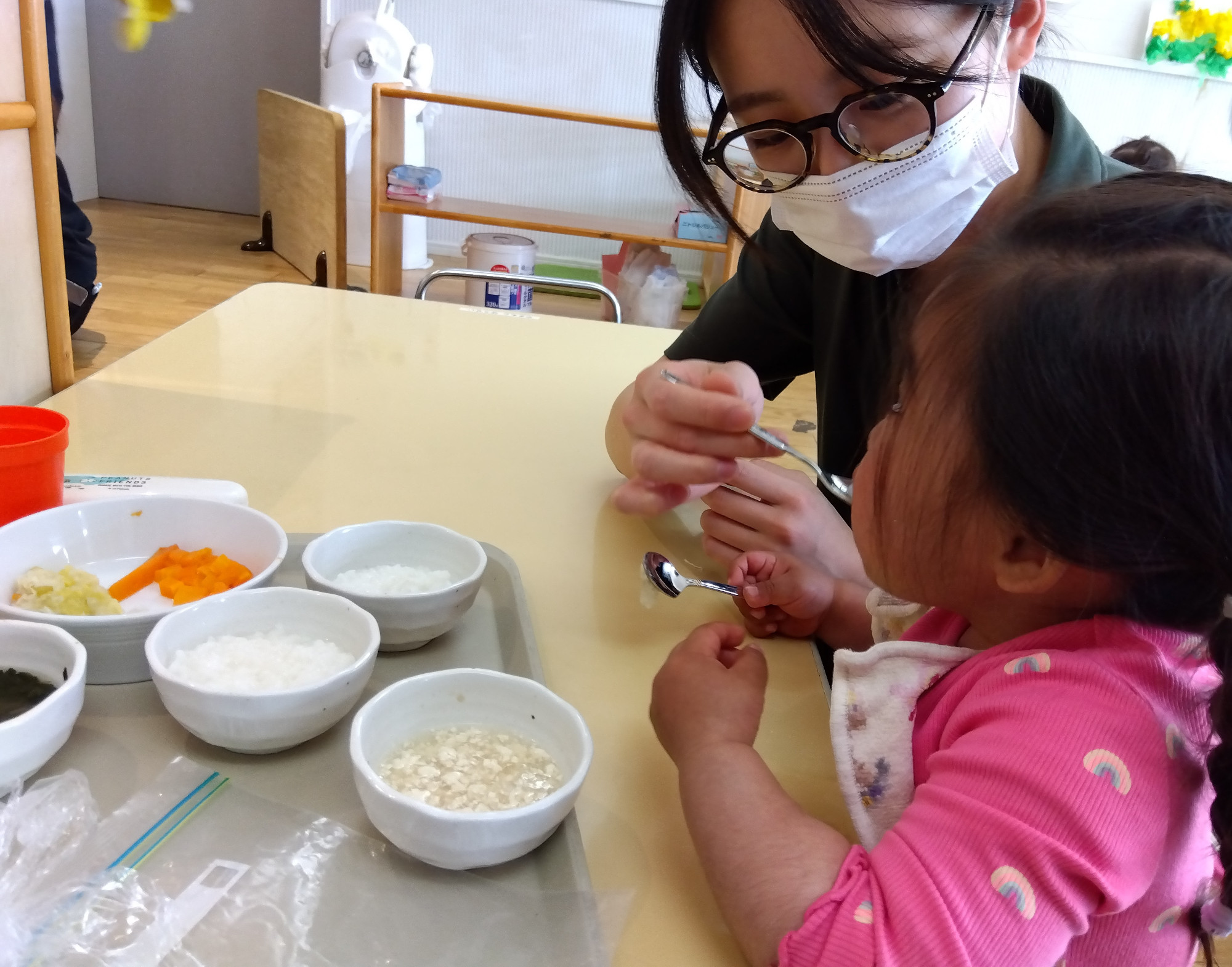乳児の食事を介助する調理スタッフ