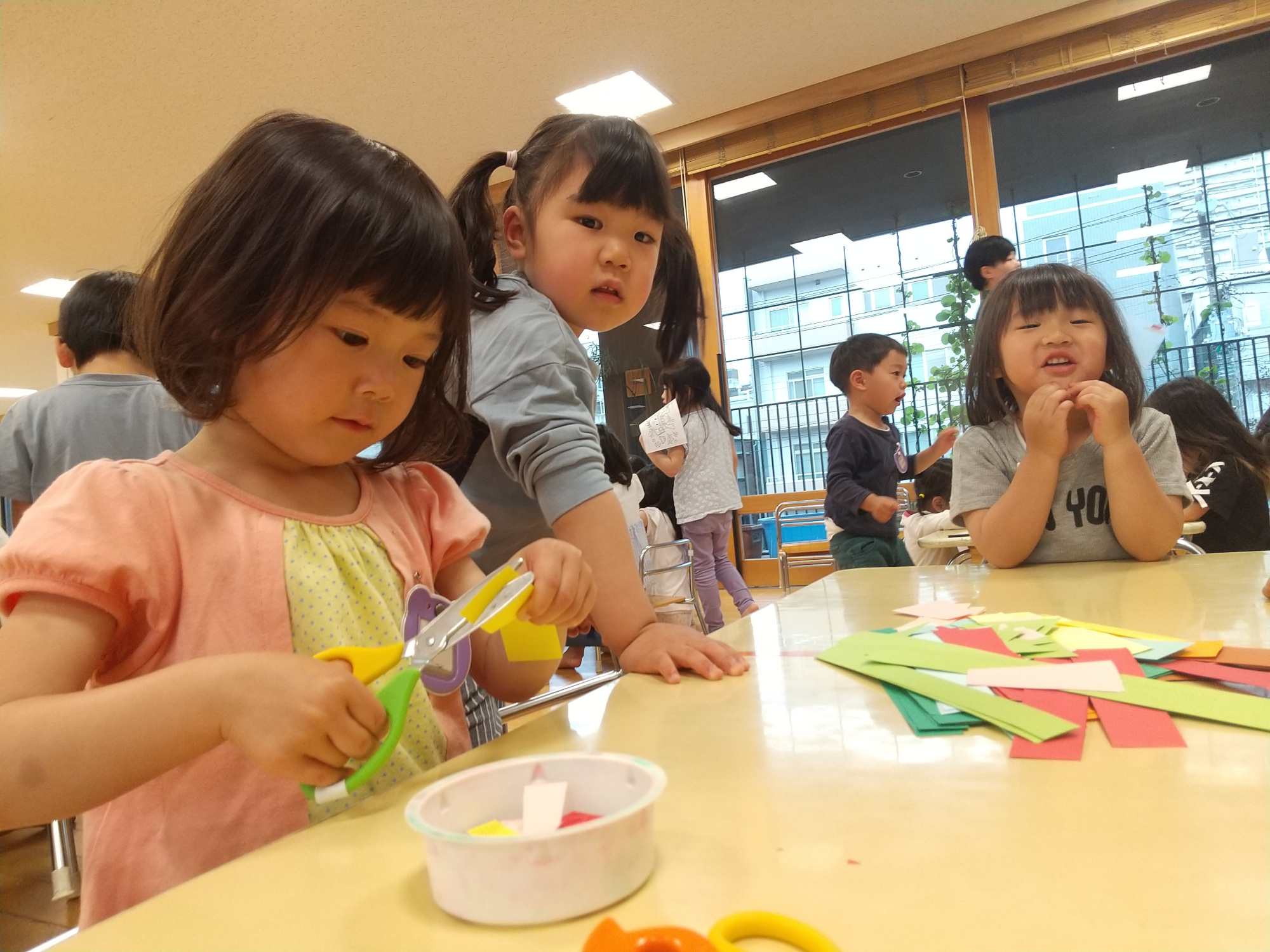 はさみで画用紙を切って鯉のぼりの鱗を作る子どもたち
