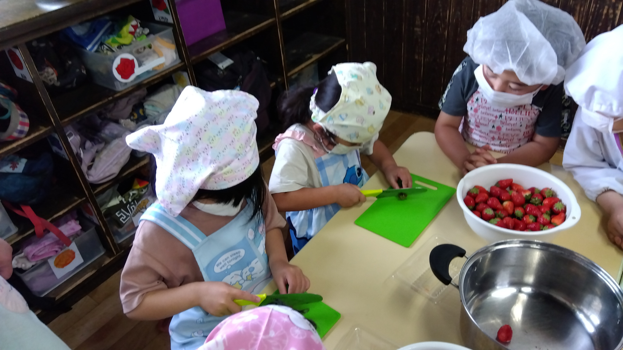 包丁を使っていちごを切る子どもたち