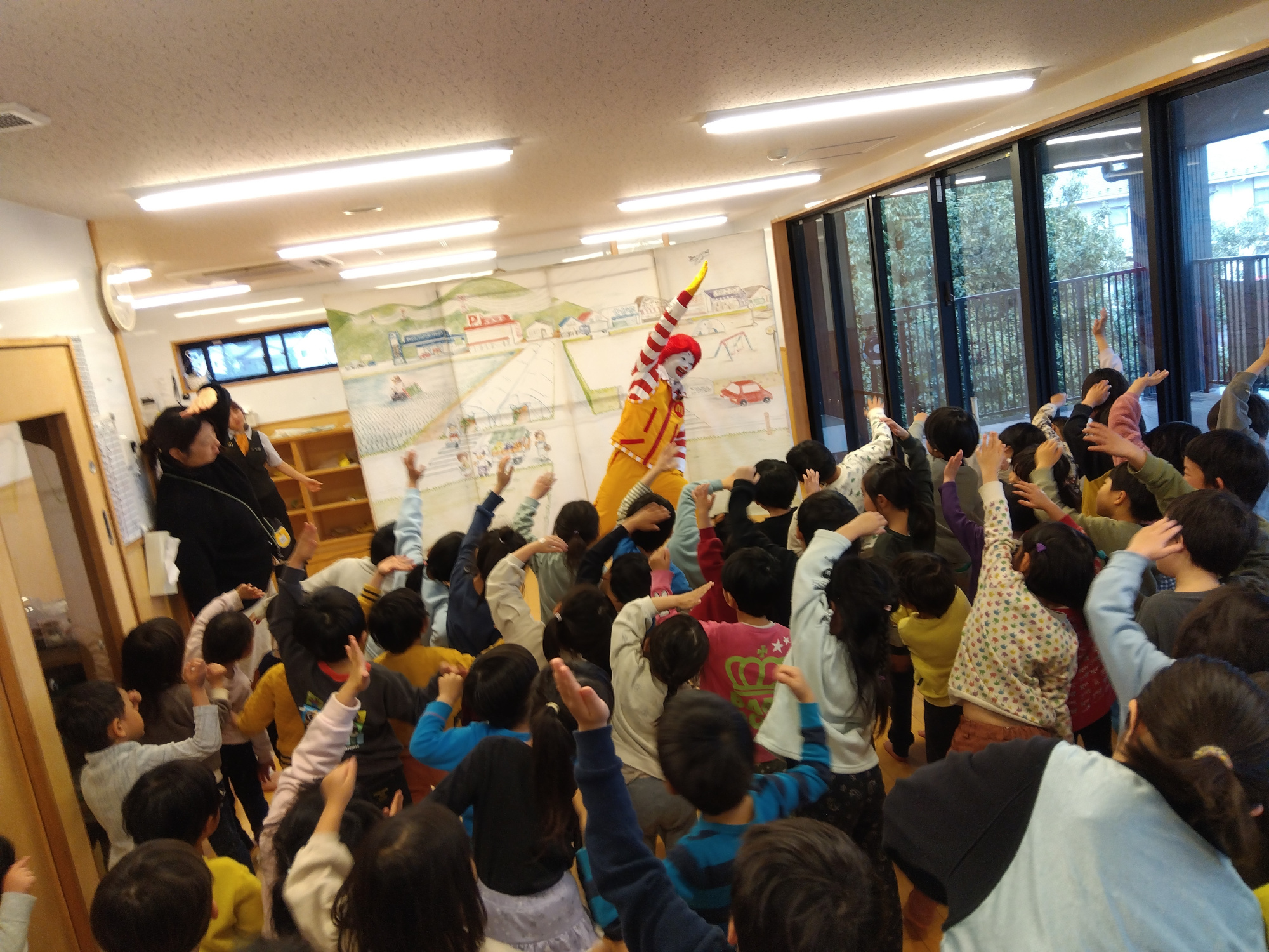 保育室内でドナルドと一緒に体を動かす子どもたち