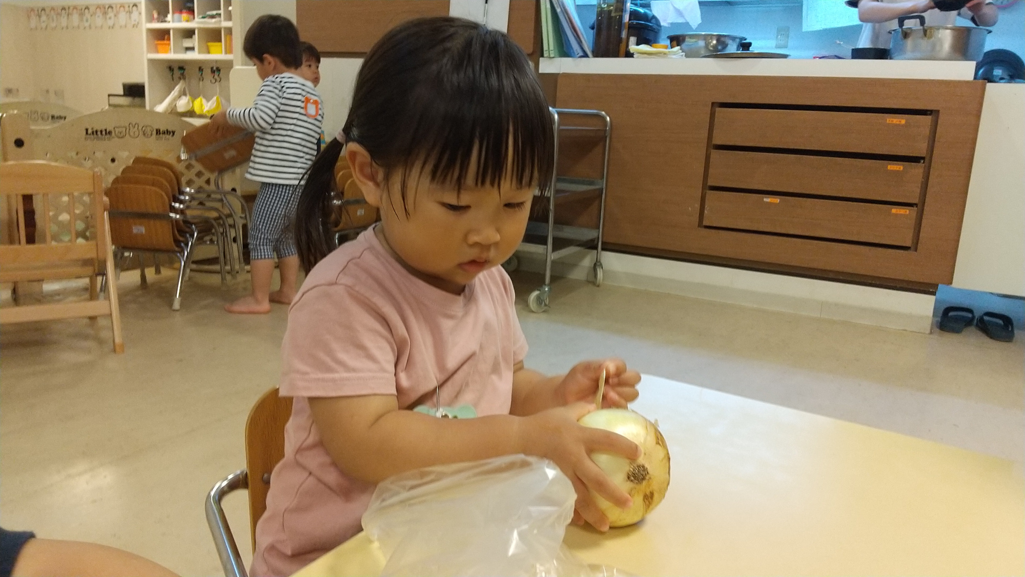 真剣な眼差しで玉ねぎの皮むきに取り組む様子