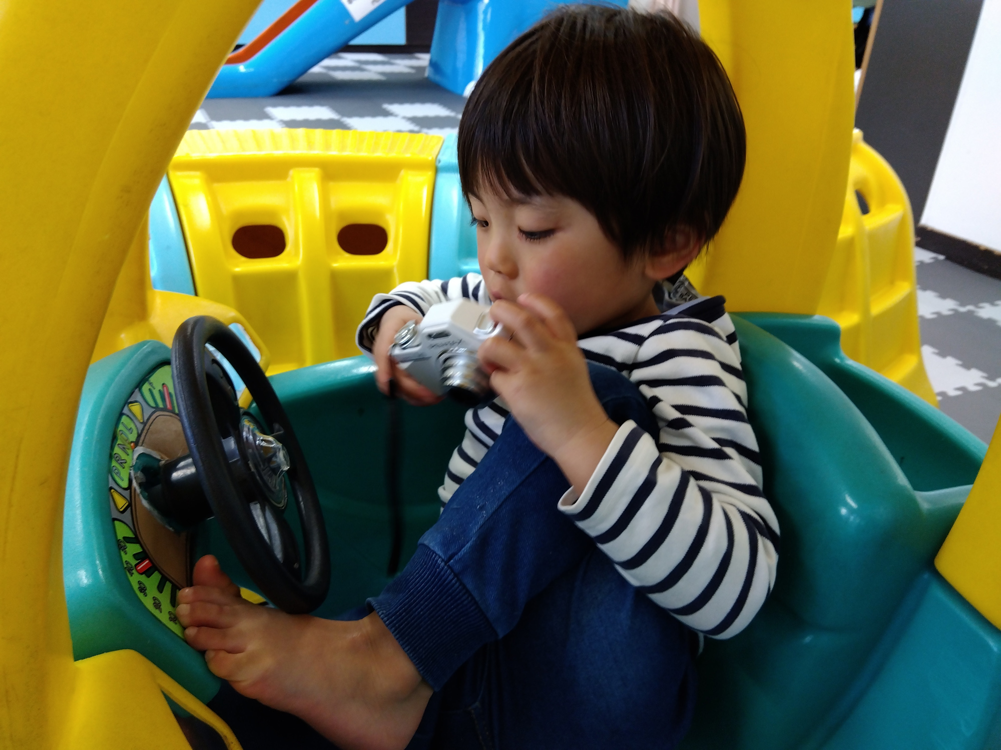 プレイルームにあるカートに乗る子ども