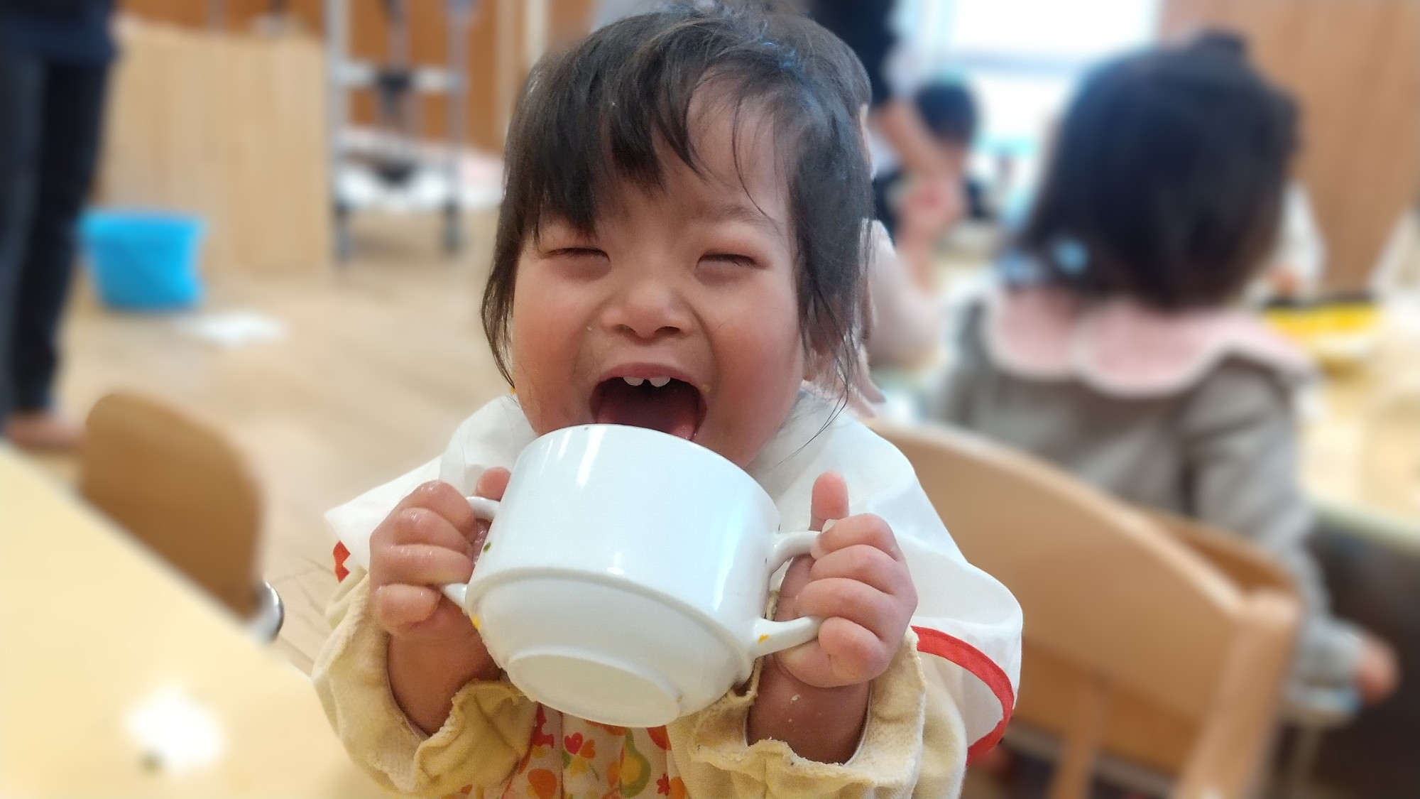 給食を食べて笑顔になる子ども