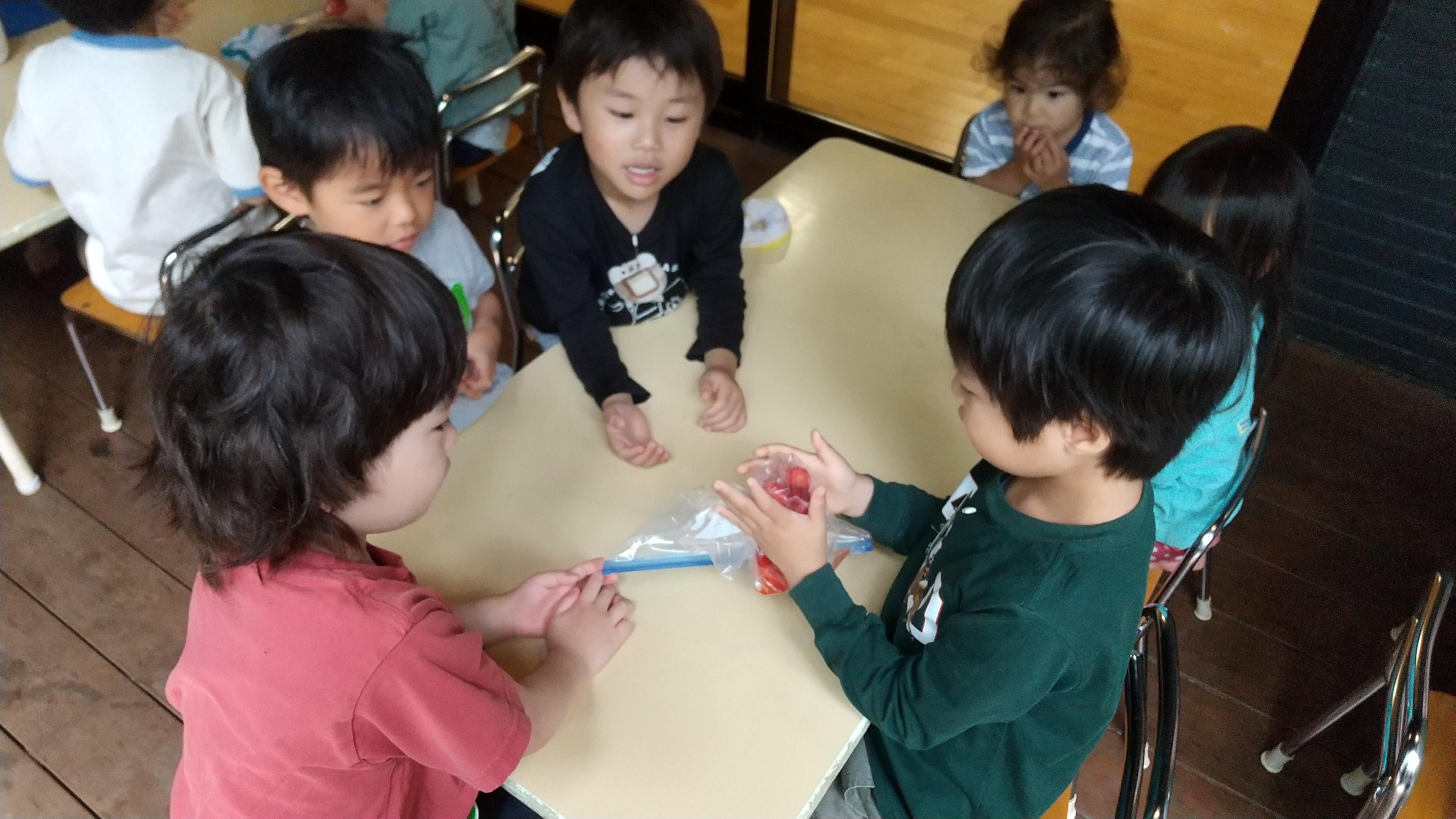 ポリ袋に入れたイチゴを潰す子どもたち