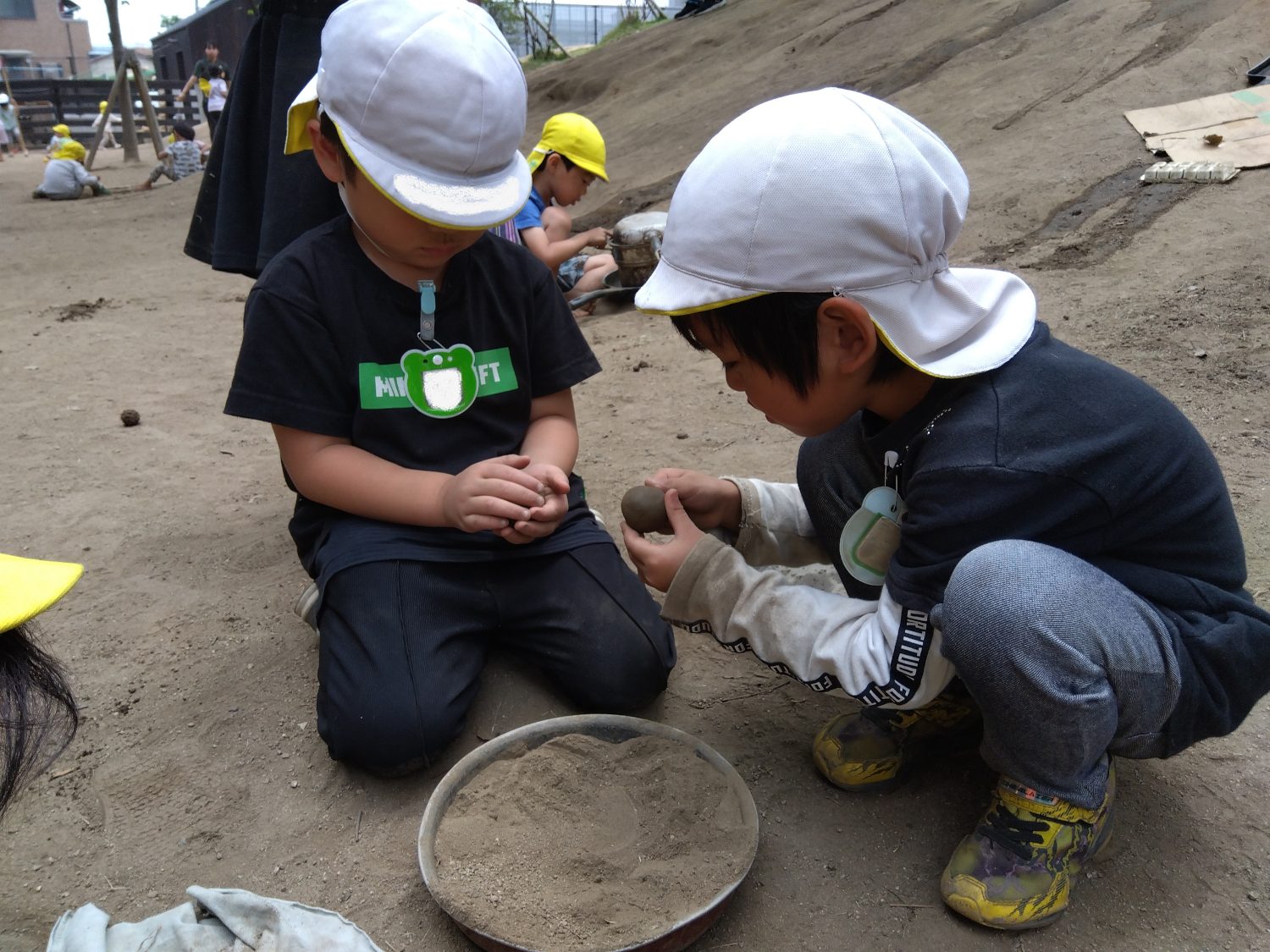 泥だんごの形を整える子どもたち