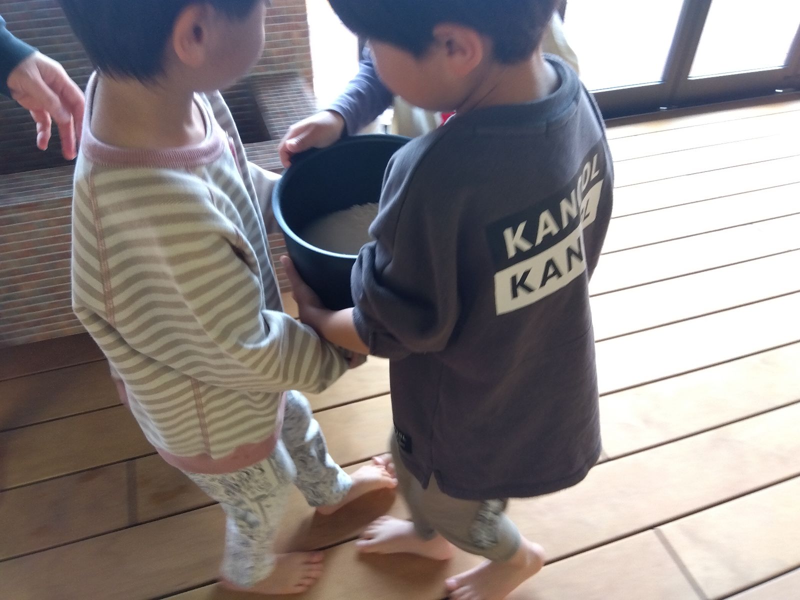 研いだもち米を協力しながら運ぶ子どもたち