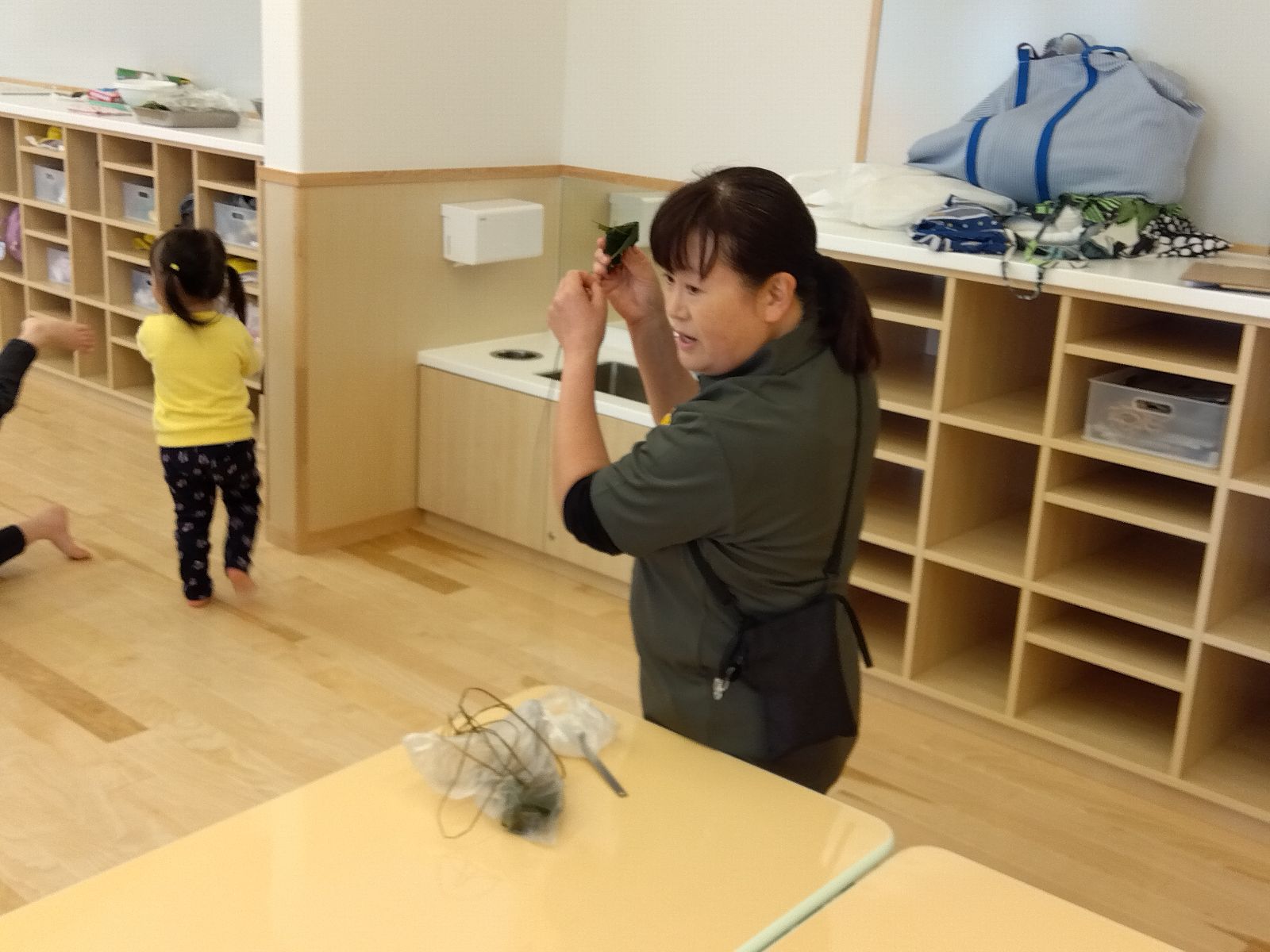 子どもたちにちまきの作り方を教える様子