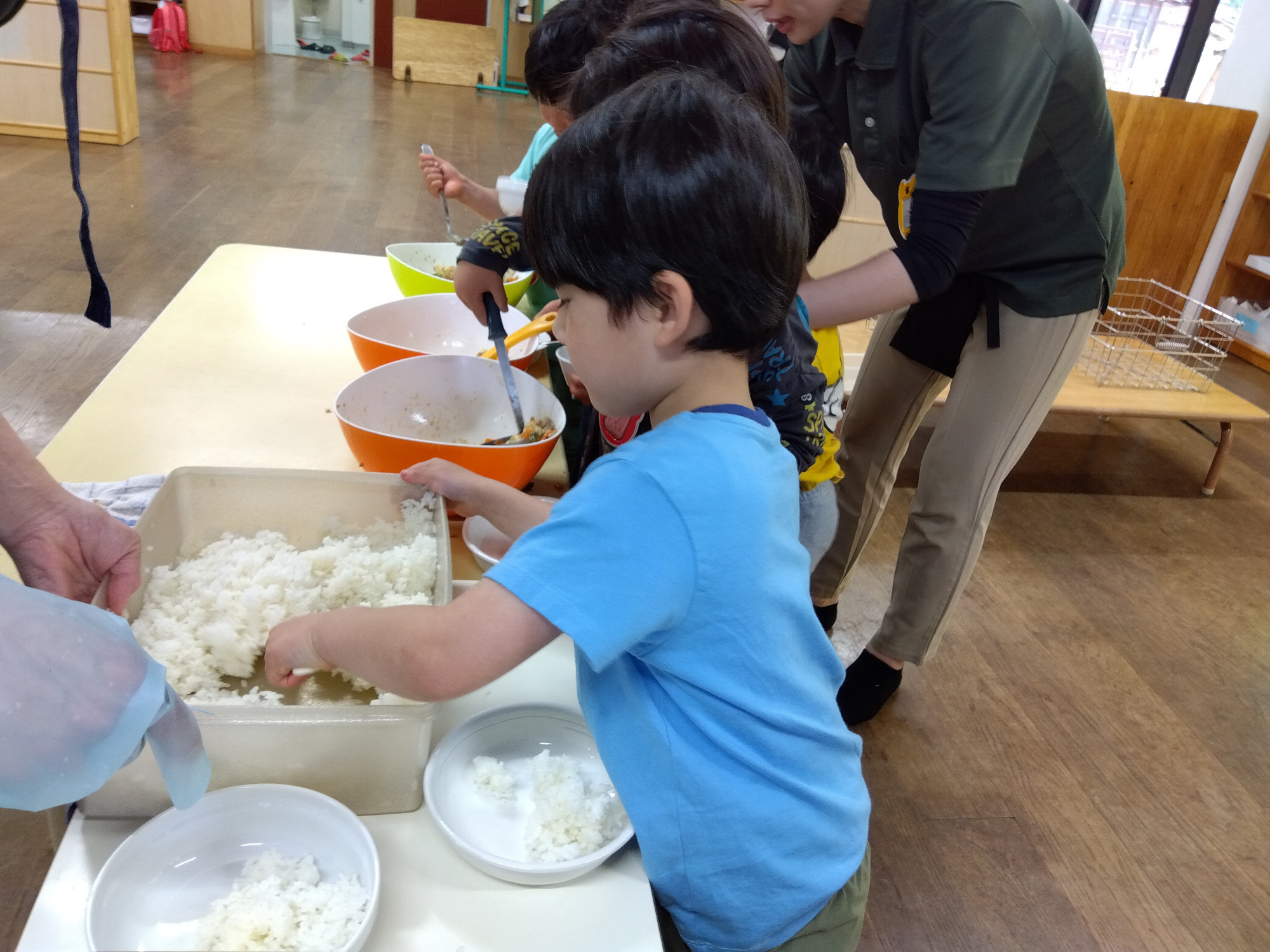 給食のごはんをよそう子どもの様子
