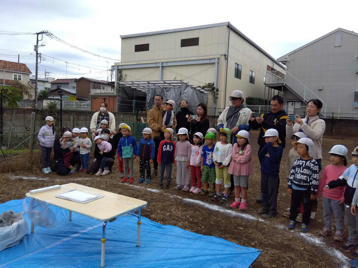 園庭に並び、鶏が捌かれるのを待つ子どもたち