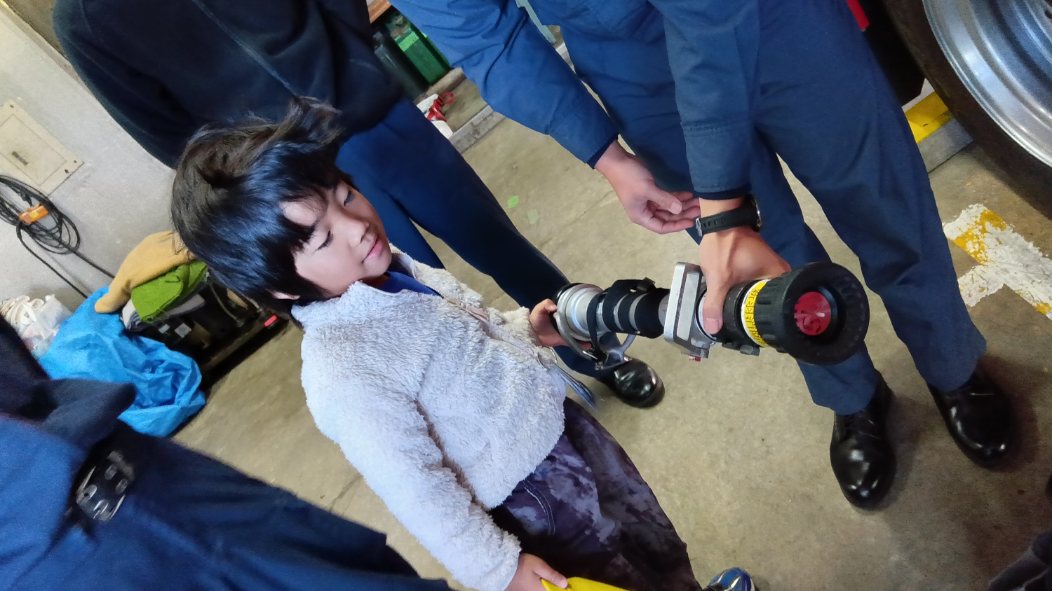 消防署の道具を触らせてもらう子ども