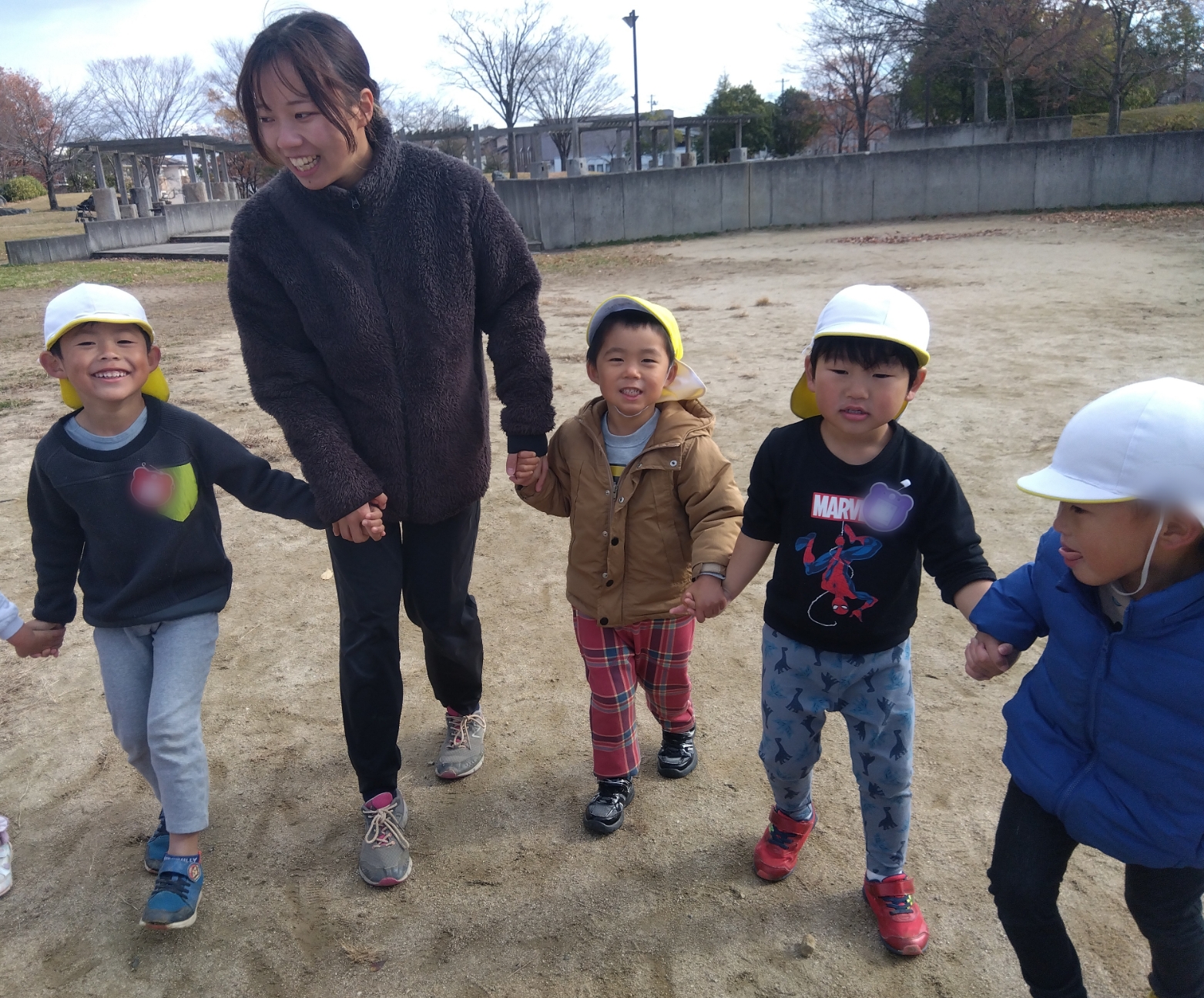 子どもたちとスタッフが手をつないで遊ぶ様子