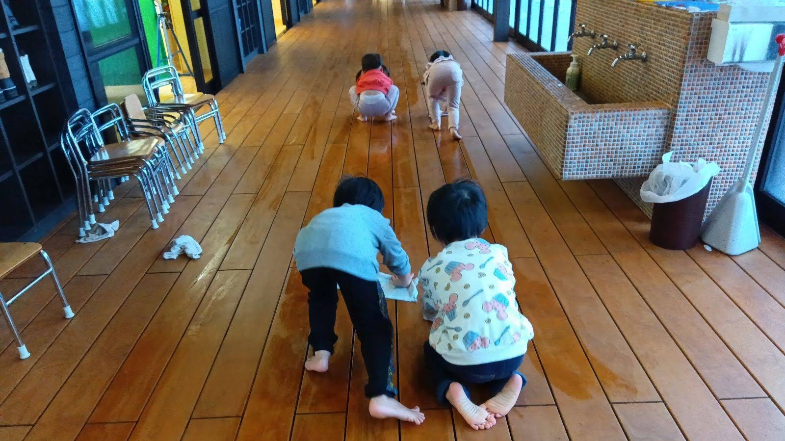 縁側を雑巾がけする子どもたち
