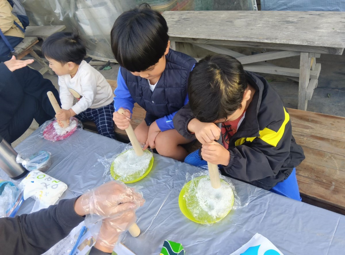 ご飯を麺棒で潰す子どもたち
