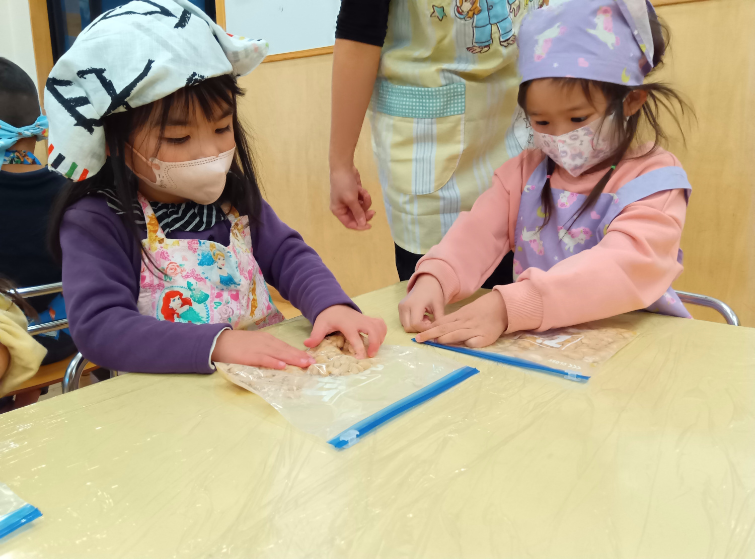 柔らかくなった大豆をつぶす子どもたち