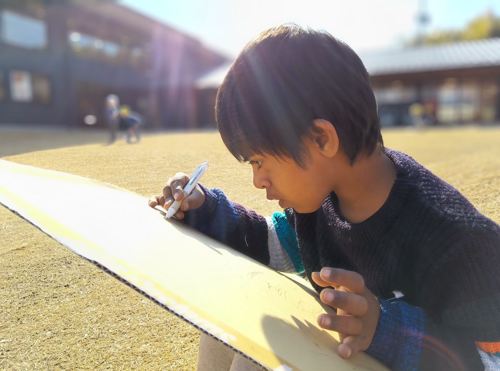 外で絵をかく子どもの様子