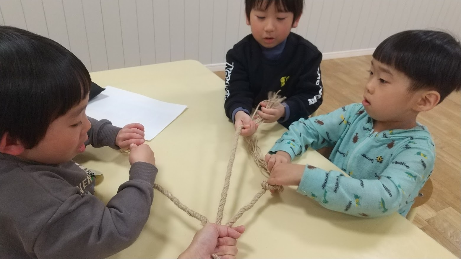 協力しながらしめ縄を作る子どもたち