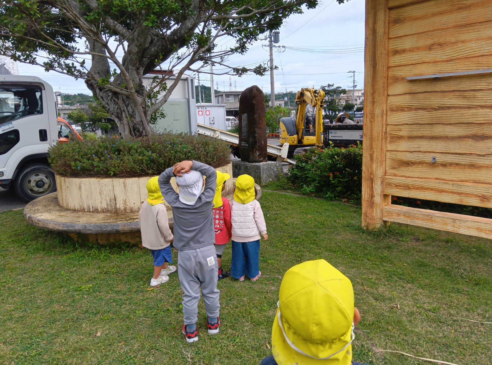 園庭での脱穀体験に取り組む子どもたちの様子