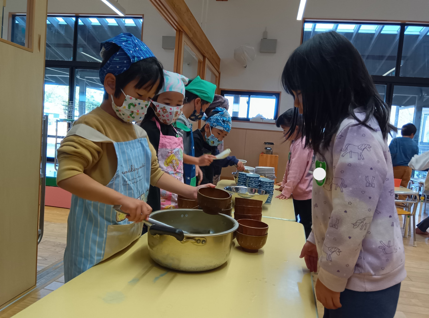 味噌汁をよそう子ども