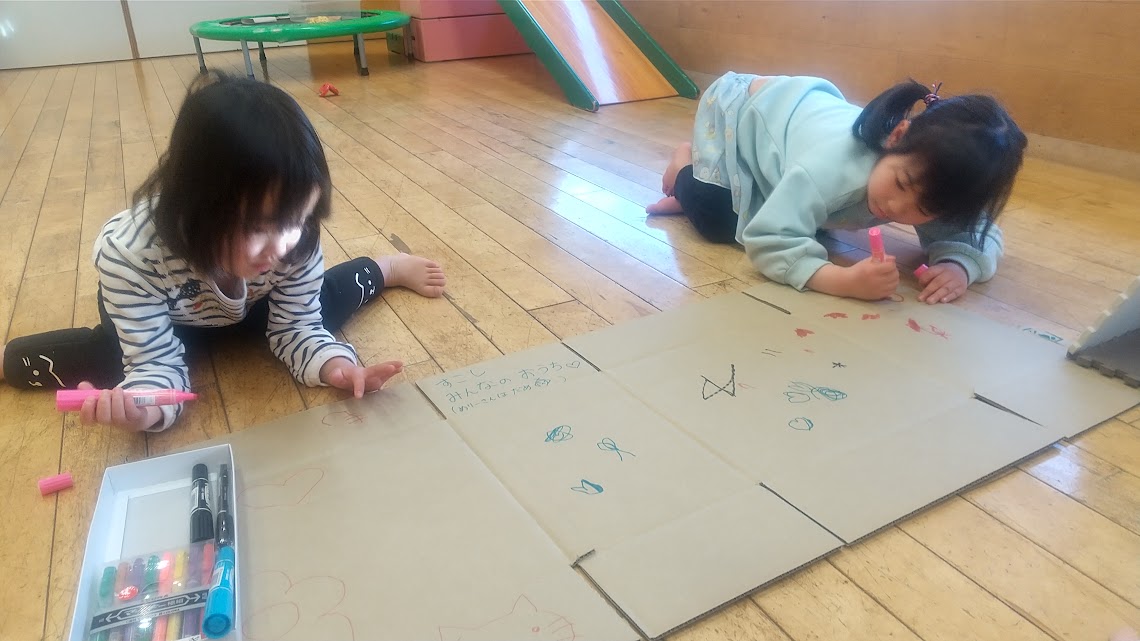 段ボールに絵を描く子どもたちの様子