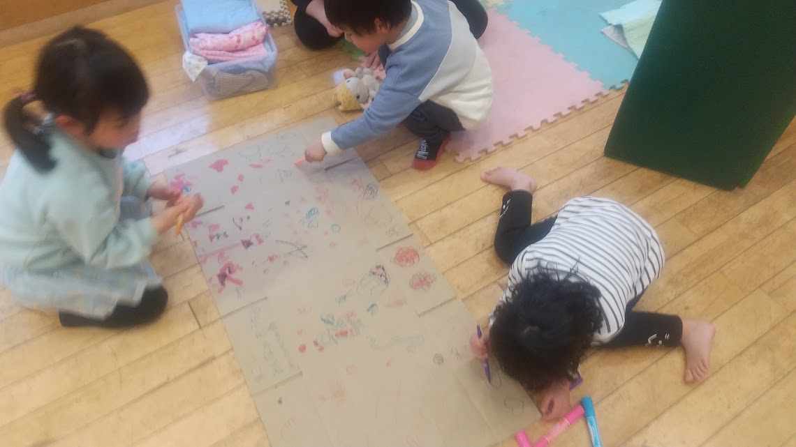 段ボールに絵を描く子どもたちの様子
