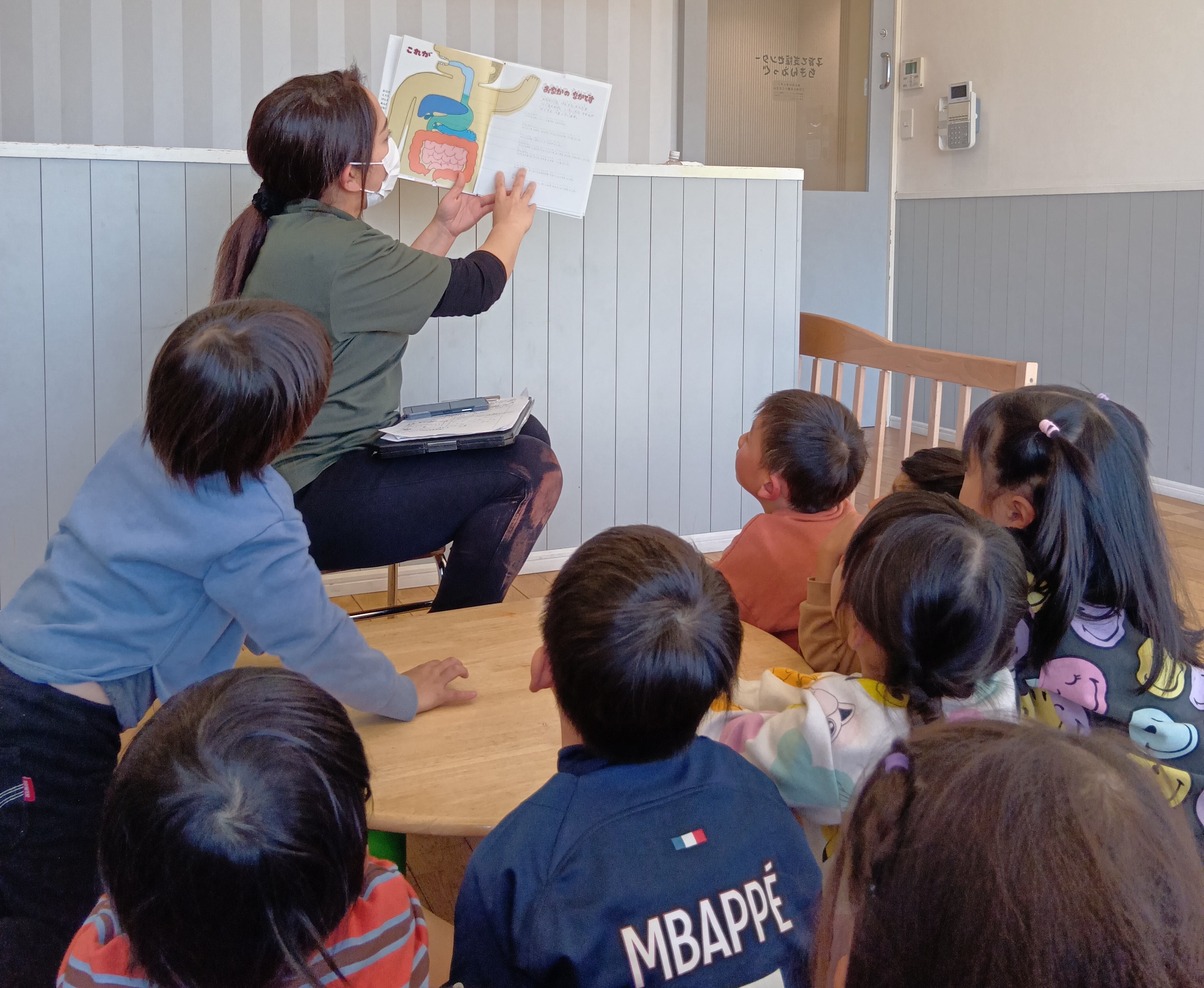 子どもに絵本を読み聞かせるスタッフ