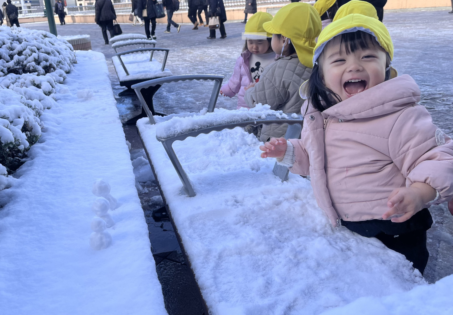 ペデストリアンデッキで雪に触れる子どもたちの様子