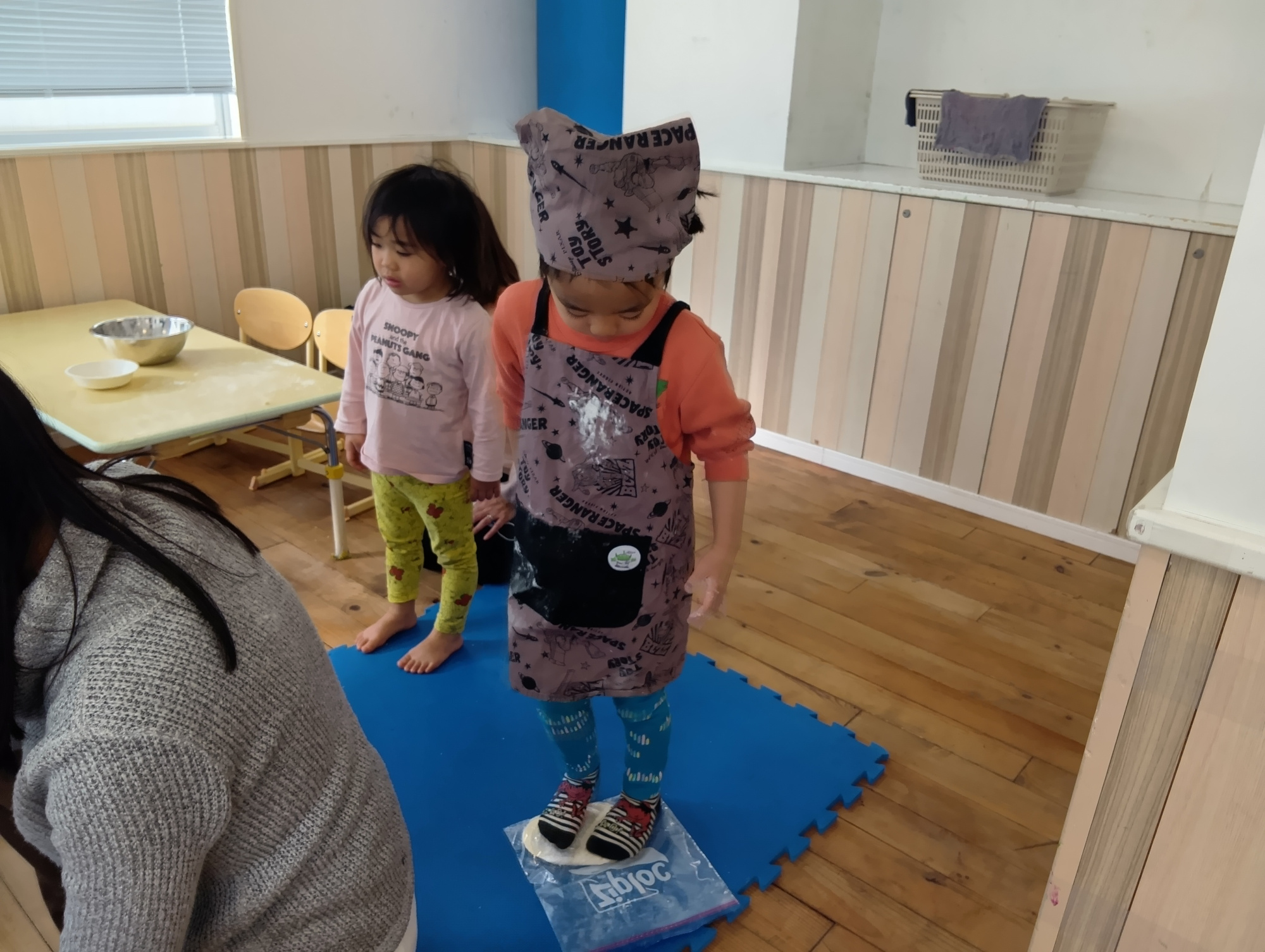 足で踏み生地を伸ばす子どもの様子