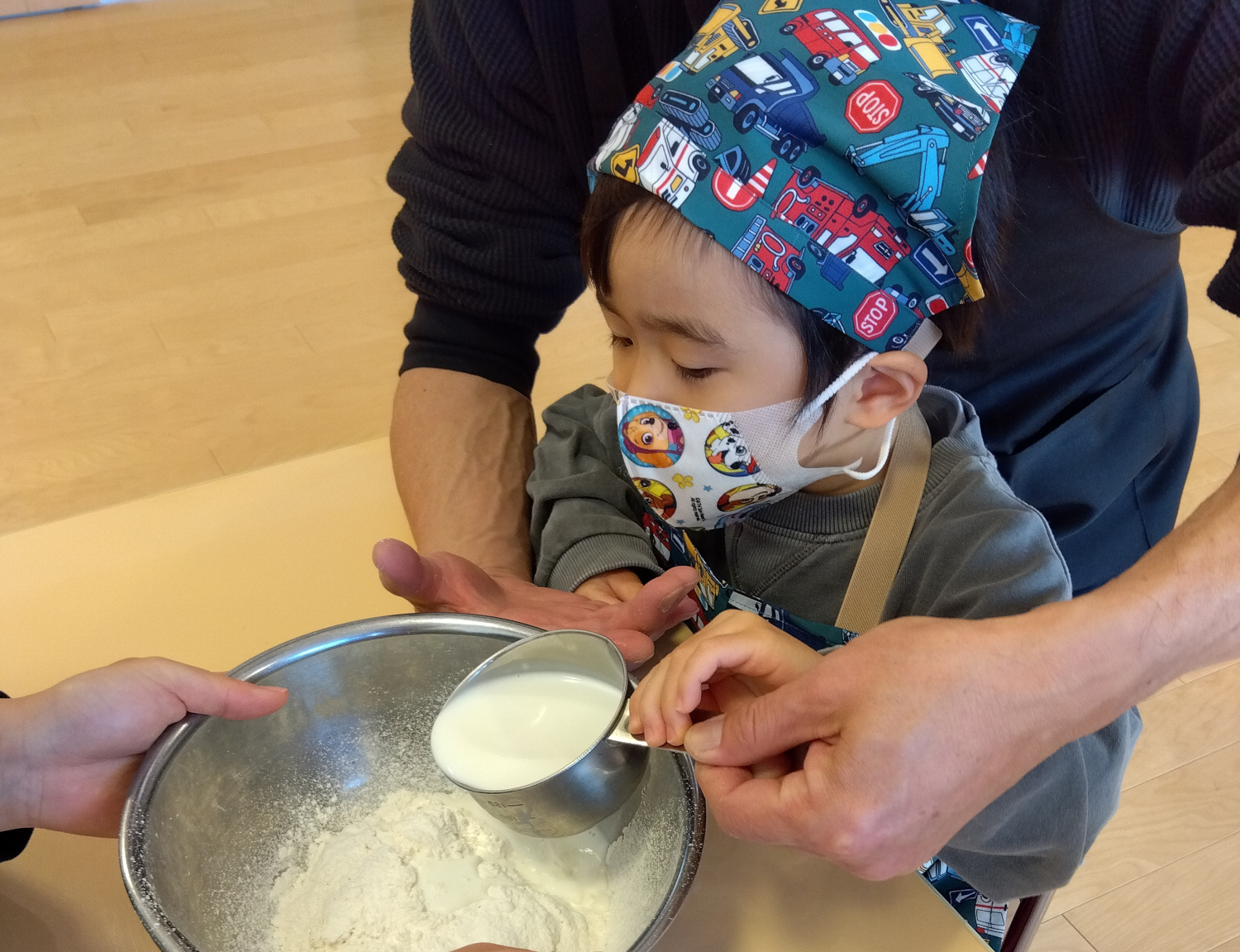 ボウルに牛乳を入れる子ども