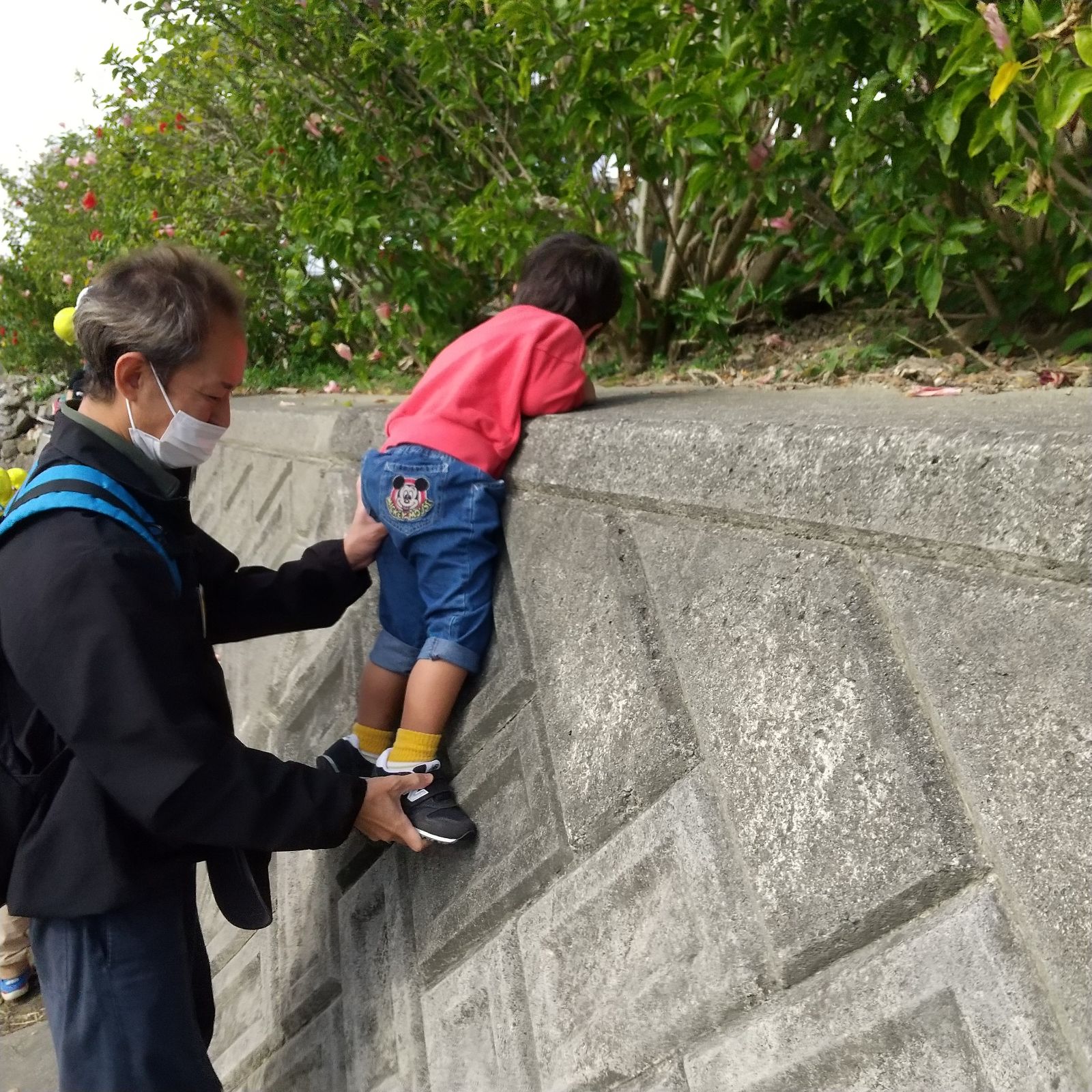 壁を登る子どもと支えるスタッフ