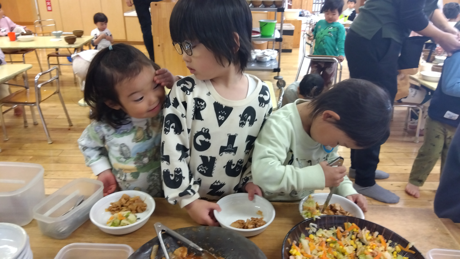 給食をお皿によそう子どもたち