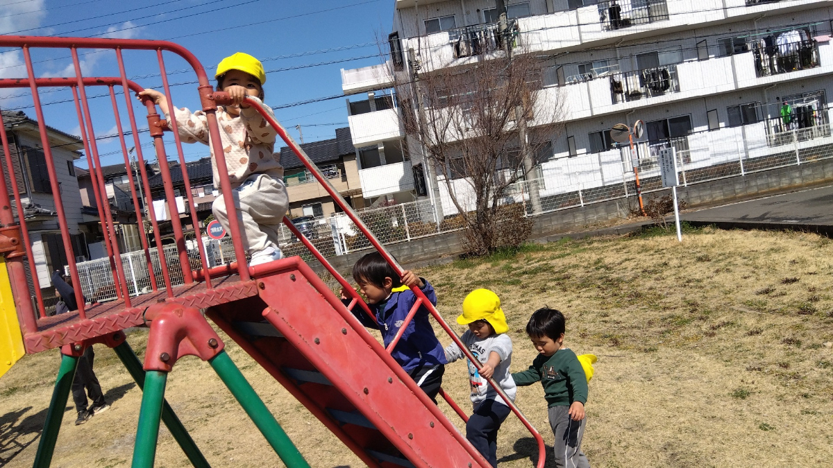 すべり台をのぼる子どもたち