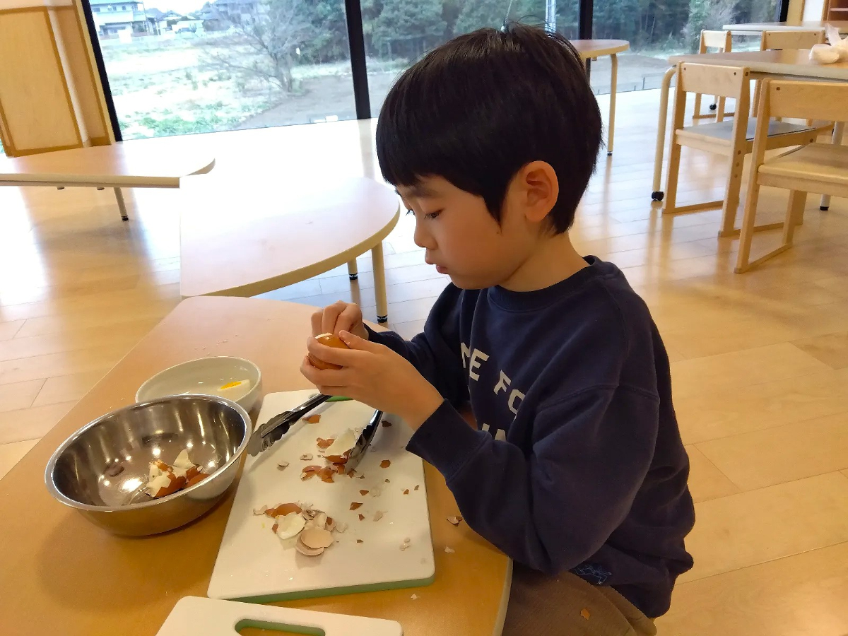 卵の殻をむく子ども