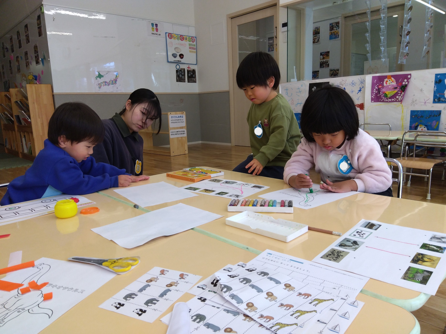 クレヨンで線を引く子どもたち