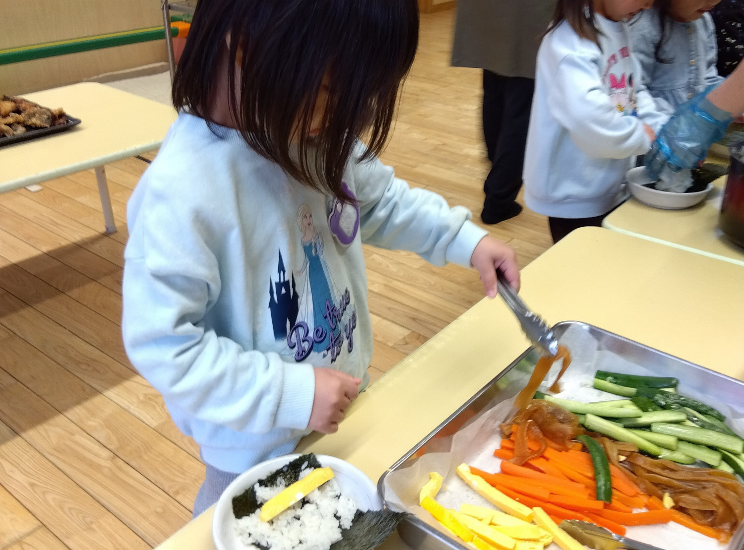 恵方巻の具材を取る子ども