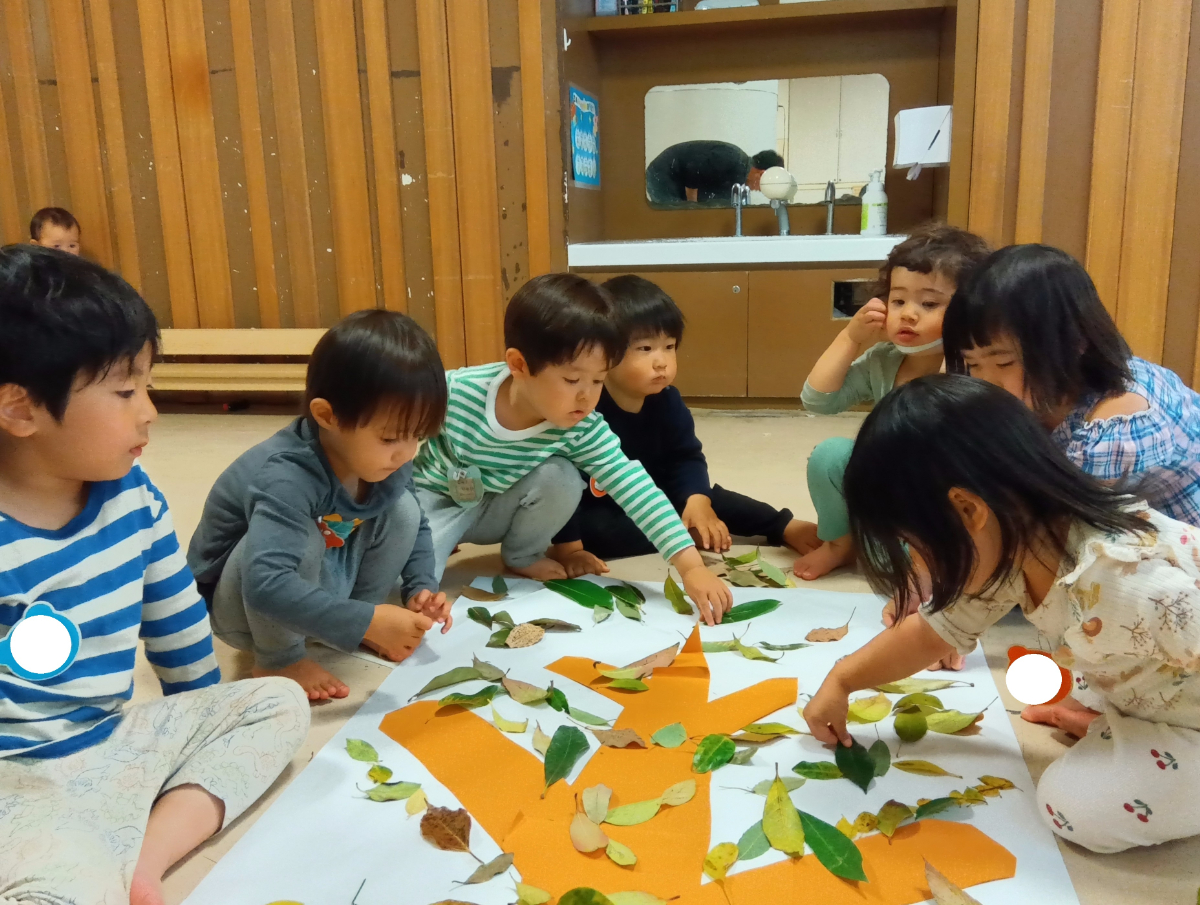 子どもたちが草花で木を描く様子