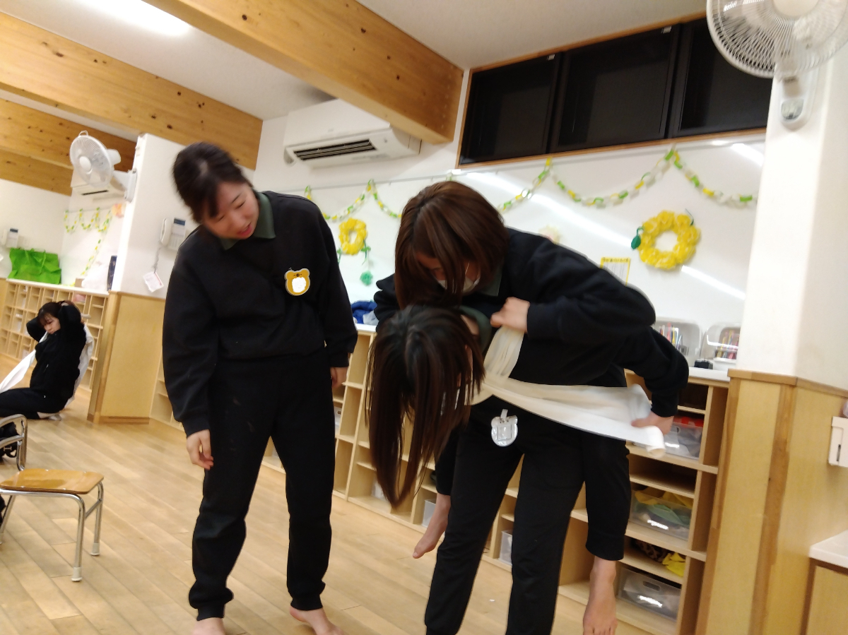 さらしを使っておんぶする職員