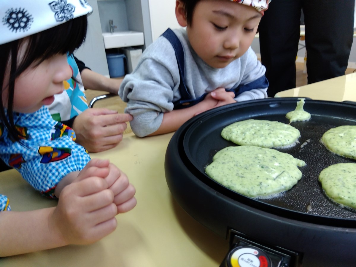 ホットプレートで焼かれるパンケーキを眺める子どもたち