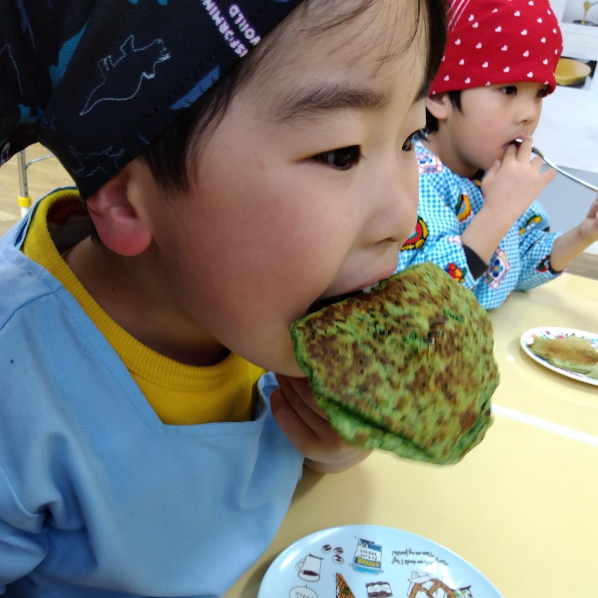 ホウレンソウのパンケーキを食べる子ども