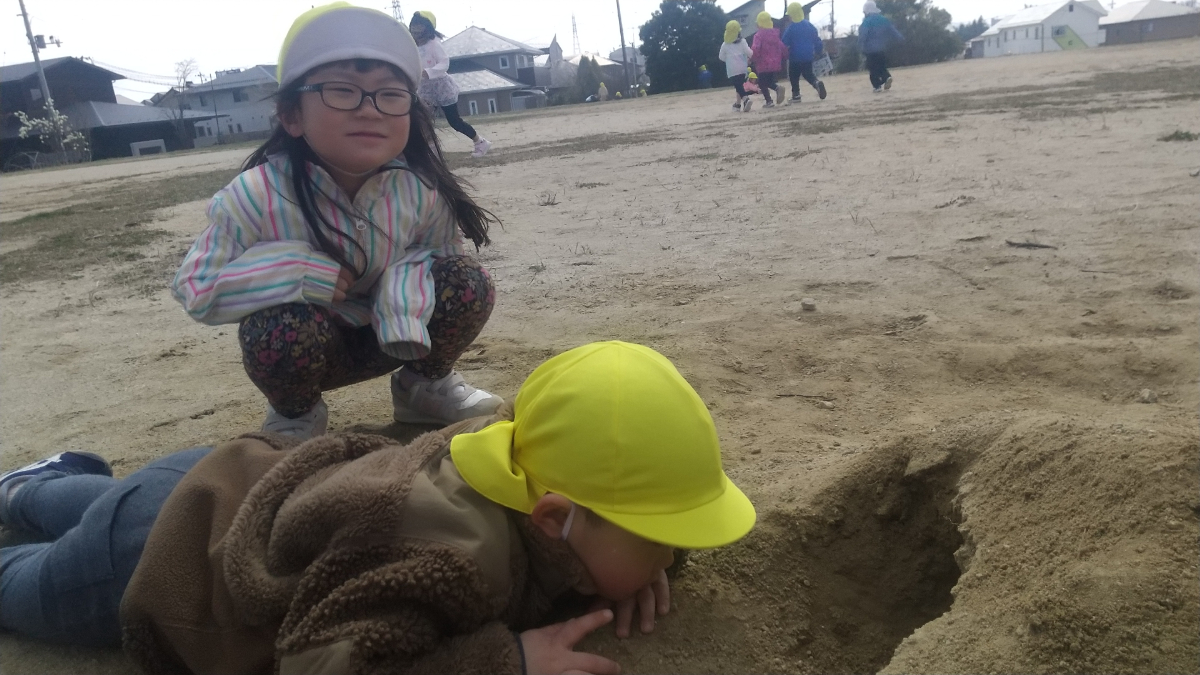 一緒に穴を掘る子どもたち