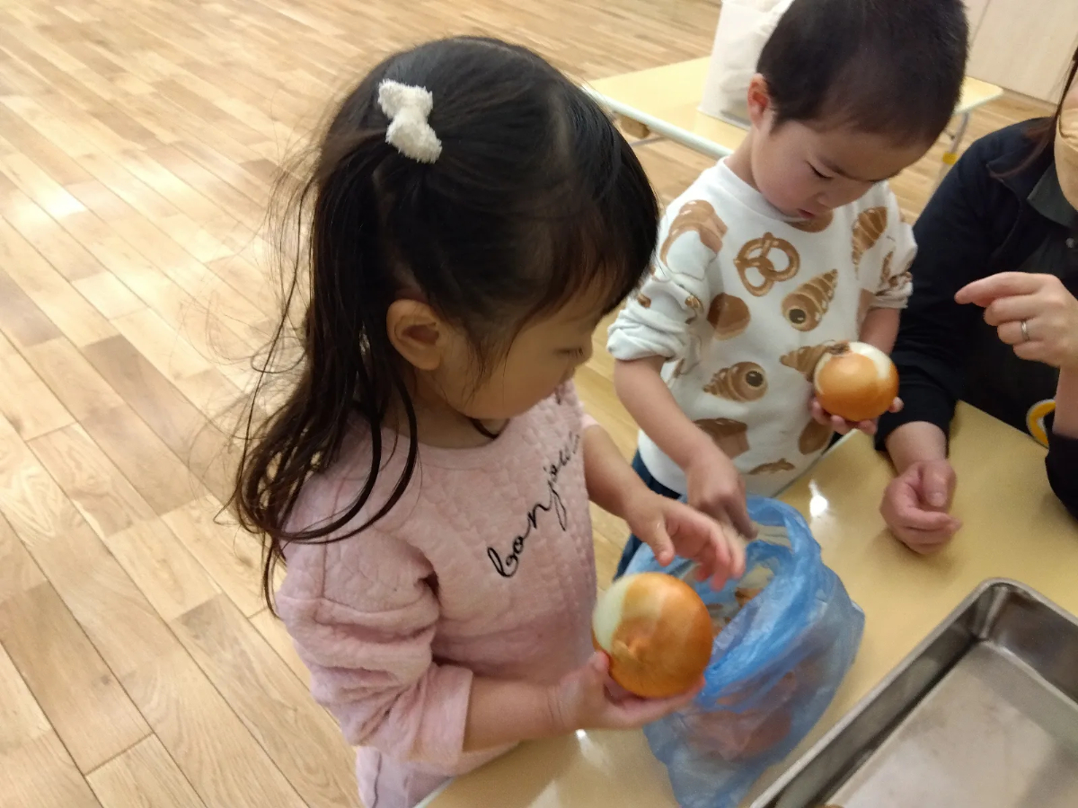 玉ねぎを手に持つ子どもたち