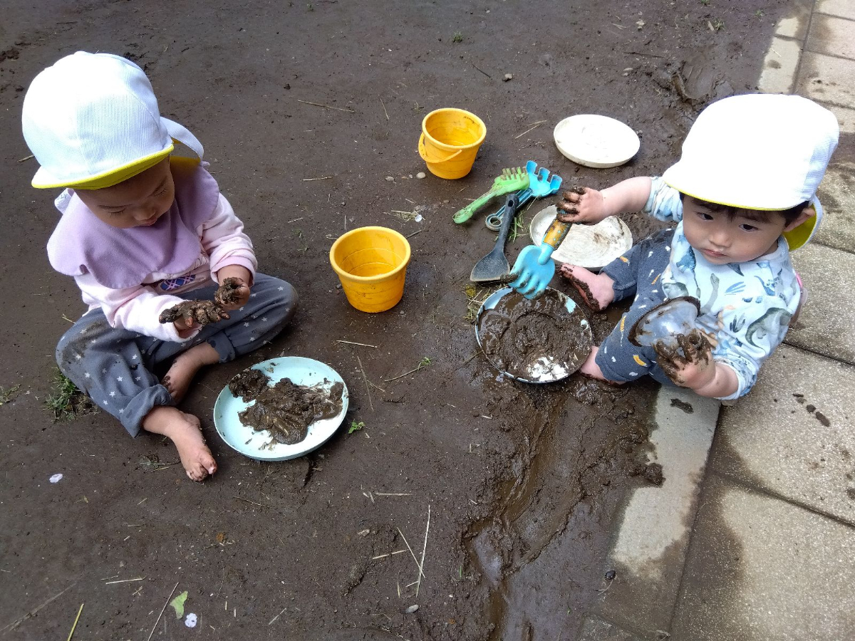 道具を使って泥で遊ぶ子どもたち