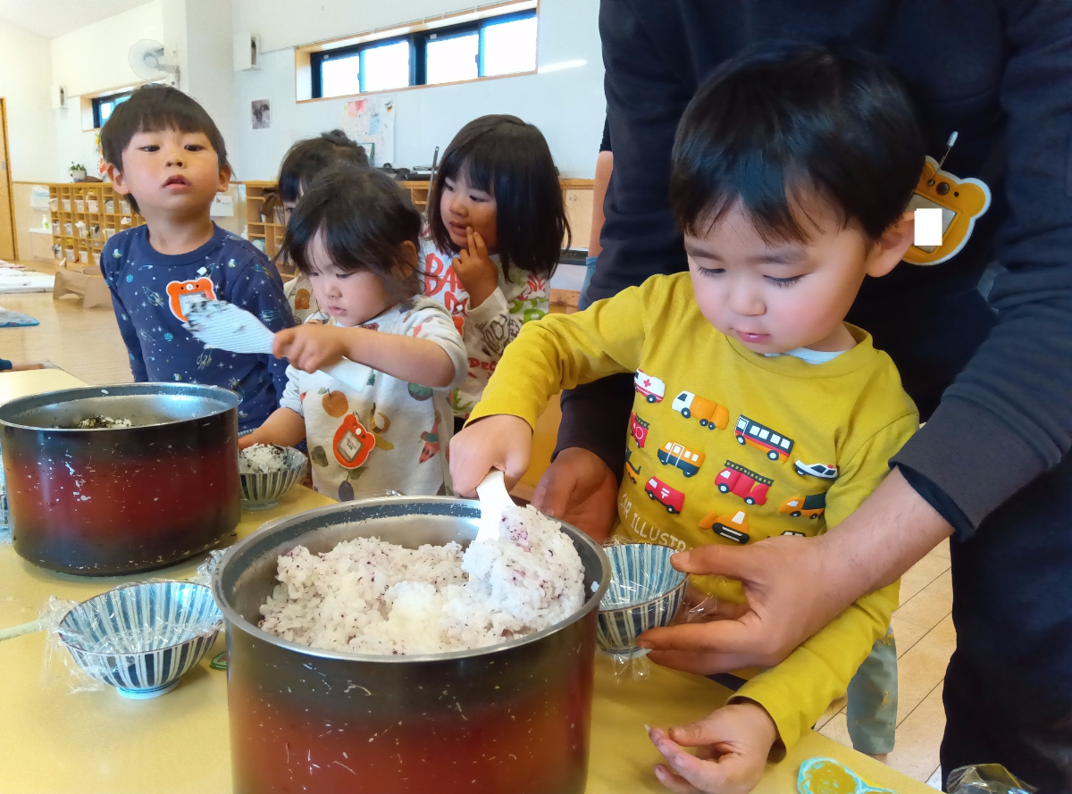 炊きあがったご飯を配膳する子どもたち