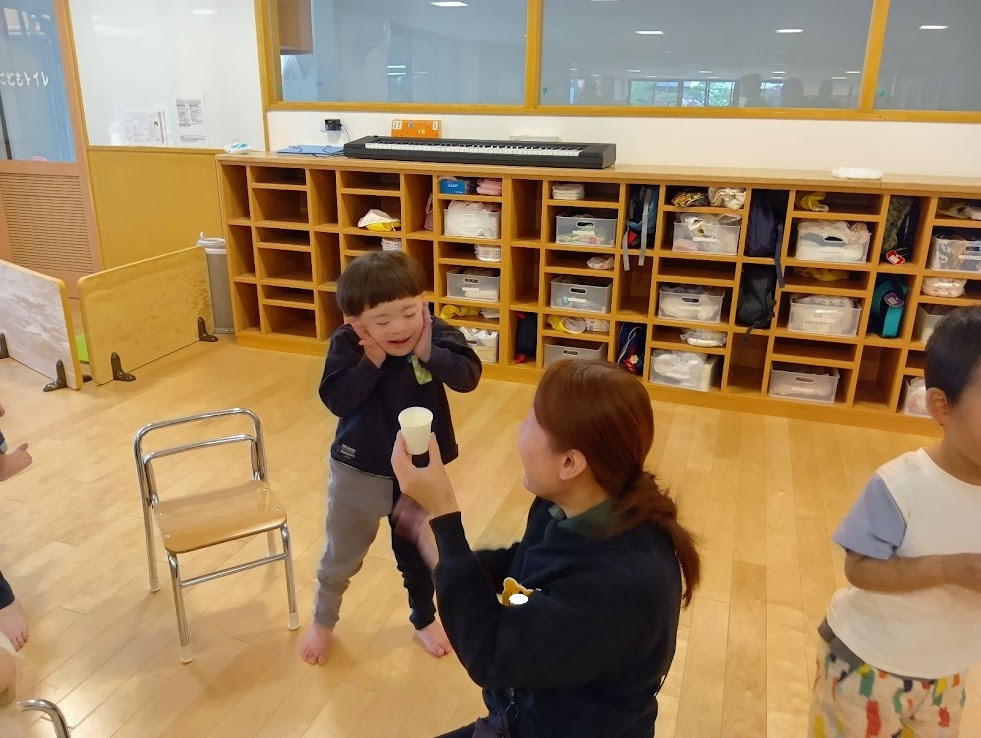 出汁を飲んで笑顔の子ども