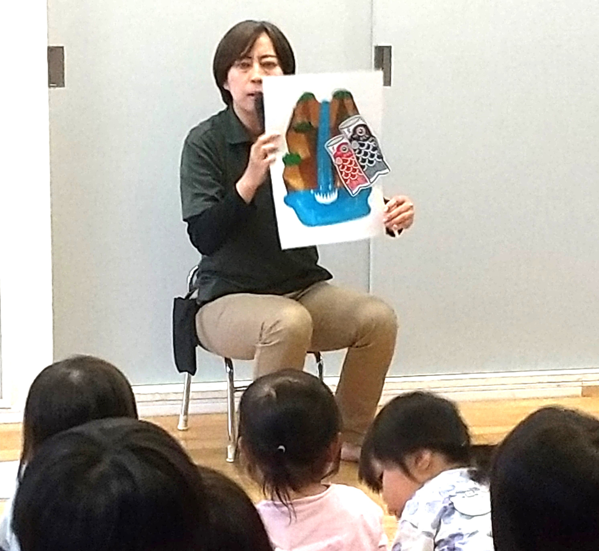 スタッフによるこいのぼりについての話を聞く子どもたち
